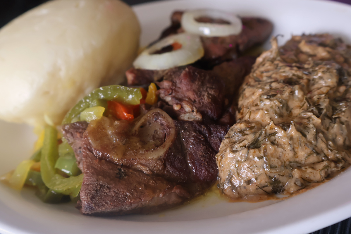 Chevre Fumbwa Fufu | Authentic Congolese goat with cassava leaves and fufu at Ma Yve Grill